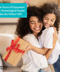 Mother and daughter embrace while holding a gift box with ribbon, promoting a hummingbird feeder as the perfect gift.