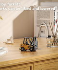 One Sixty Fourth Scale Alloy RC Forklift Toy With Lights And Sounds on a wooden desk with decor items in the background