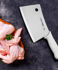 7 Inch Meat Cleaver With High Carbon Steel Blade Textured Slip Resistant Handle NSF Certified Heavy Duty Butchering Knife For BBQ And Kitchen Prep Made In USA next to raw chicken pieces