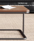 Close-up of modern square nesting coffee table set of two, featuring tall metal legs and solid wood surface.
