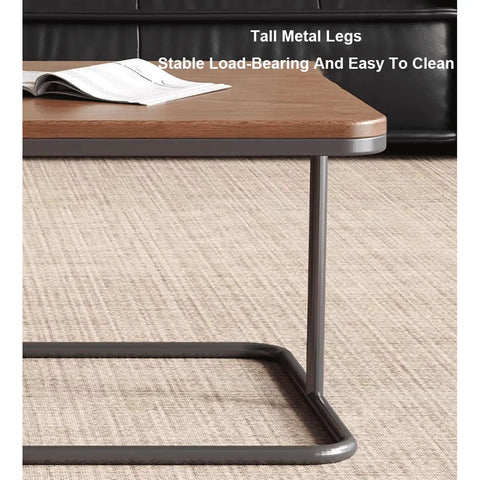 Close-up of modern square nesting coffee table set of two, featuring tall metal legs and solid wood surface.