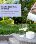 Image of Water Filter Pitcher 10-Cup BPA Free Wisteria for Everyday Protection pouring water into glass outdoors.