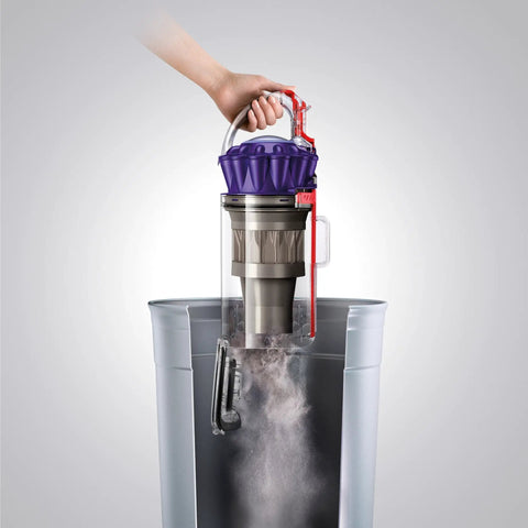 Hand removing canister of Pet Hair Be Gone Upright Vacuum With Ball Steering, Corded Power For Carpet And Hard Floors for cleaning