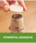 Applying beige 1-inch felt pad with self-stick adhesive to wooden furniture leg for floor protection from nicks and scratches.