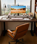 Rock Solid Electric Standing Desk Crafted From Genuine Solid Rubberwood Desktop With Quick Motorized Height Adjustment For Comfortable Home Office Computer Workstation with brown chair and monitor in home office.