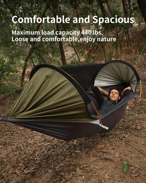 Person lounging in 4 In 1 Camping Hammock Tent With Mosquito Net And Removable Sunshade, supported by tree straps in a forest.