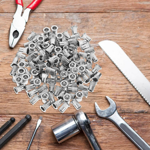Flat Head Knurled Rivet Nuts Kit Stainless Steel 120 Piece Set Threaded Rivets on a wooden surface with tools