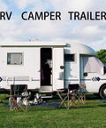 White RV camper trailer parked on grass with chairs outside, showcasing outdoor travel lifestyle.