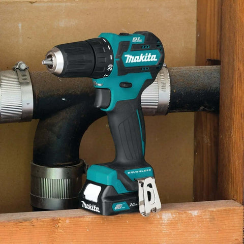 Ultra Compact 12V Max CXT Brushless Cordless Driver Drill resting beside plumbing, showcasing its compact size and design.