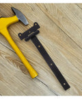 Sealed Bearing Gate Hinges Beefy T Shaped Hinge Black Finish next to hammer on wooden floor