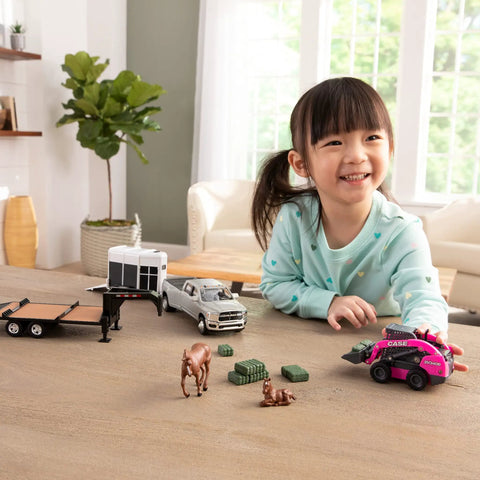 Child playing with CASE SV340B Skid Steer Loader Toy Set With Flatbed Trailer RAM Pickup Horse Trailer And Two Horses.