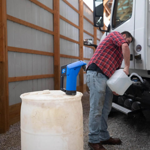 Heavy Duty Hand Operated Diesel Exhaust Fluid Transfer Pump For 55 Gallon Drums on a white barrel with a user filling a container.
