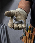 Killer Grip 20 Pack PVC Pipe Clamps Half Inch Conduit Straps held in gloved hand for secure wiring and cable routing installation.