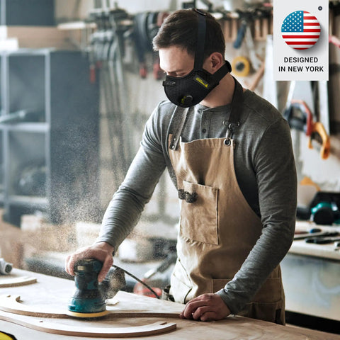 Man woodworking wearing Dust Mask With Carbon Filters And Air Valves, Reusable Three Size Fit For Woodworking, Construction And Moving, Black Large