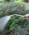 18 Inch Soft Rain Watering Wand With Shut Off Valve in use, watering garden greenery with gentle spray.