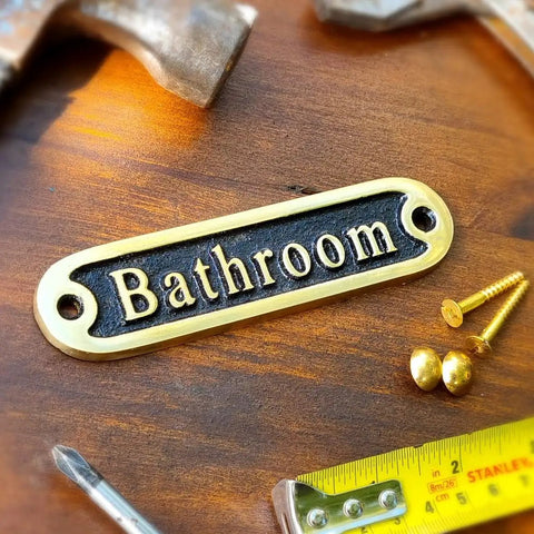 "No Soliciting Brass Door Sign For A Chill Home Traditional Style Wall Plaque Handcrafted Metal Decor Solid Brass Sign To Keep Unwanted Callers Out Classic Rustic Entryway Door Accent" displayed on a wooden surface with screws and tools.
