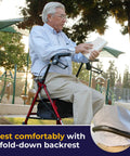 Rock Solid Red Rollator Walker With Cushy Seat And Steel Frame For Smooth Indoor Outside Navigation Heavy Duty Senior Mobility Aid 7.5 Inch Wheels Built Tough All Day Long Ride. Senior man reading while seated on rollator.