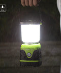 Person holding 1000 Lumen Battery Powered LED Camping Lantern With Four Light Modes in rain showing IPX4 waterproof feature.