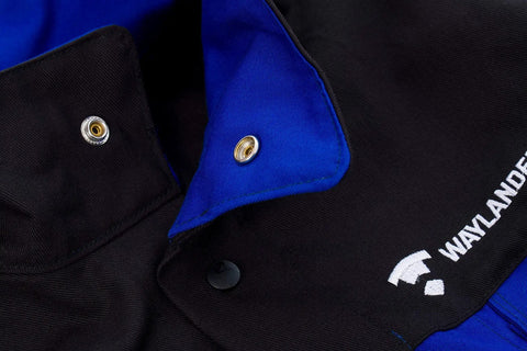Close-up of Flame Resistant FR Cotton Welding Jacket With Snap Front And Wrist Closures In Black And Blue, showing snap detail.