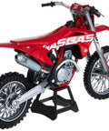 GasGas MC 450F One Twelfth Scale Diecast Motorcycle Model in red with real rubber tires and rolling wheels on a stand.