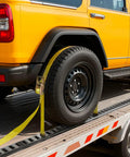 Yellow vehicle secured with an E Track Tie Down Rail Kit 4 Pack 2 Ft Rails with Ratchet Straps on a trailer