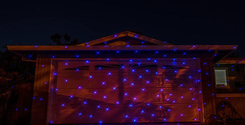 Motion Snow Fall Light Show With White Laser And 7 Color Star Effects Christmas Lights on garage door at night
