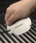 Hand using saw tooth grill scraper from 36 Piece Grill Tool Set With Spatula Fork Tongs Basting Brush Replacement Brush Heads