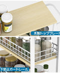Close-up of a Slim 4 Tier Rolling Storage Cart With Wood Top For Narrow Spaces, showing wood top and steel shelves with spices.
