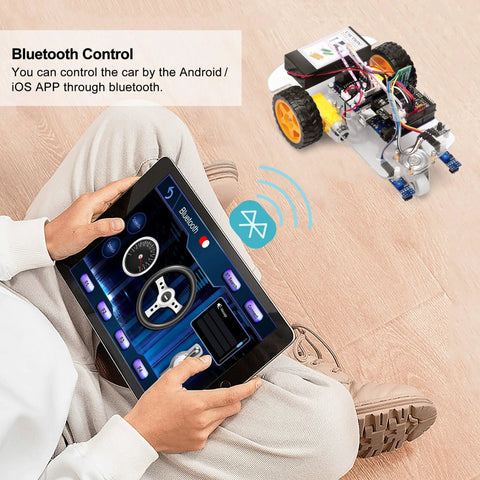 Man using tablet to control 2WD Arduino Robotic Car Starter Kit For Beginners And Adults Hands On Smart Educational Robotics Set To Build Code And Control Via WiFi Bluetooth And IR Learn Programming And Electronics The No Brainer Way