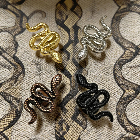 Snake Shaped Cabinet Knobs Set of 4 Dope Black Zinc Alloy Drawer Pulls and Door Handles on patterned fabric
