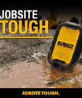 Yellow rugged portable speaker labeled 'Dewalt' standing on a muddy construction site, showcasing its durability.