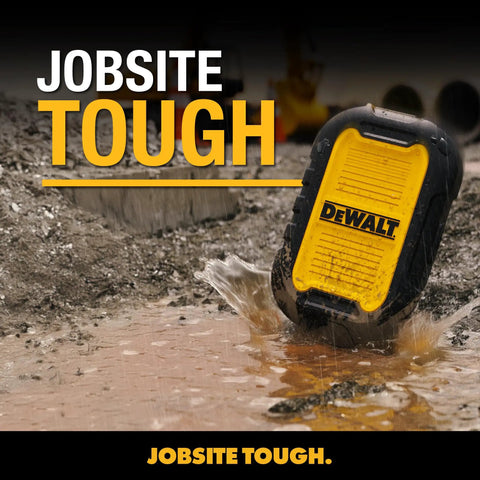 Yellow rugged portable speaker labeled 'Dewalt' standing on a muddy construction site, showcasing its durability.