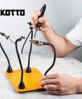 Person using Third Hand Soldering Tool With Four Magnetic Gooseneck Arms And Stainless Clips For PCB Holder Soldering Repairs Jewelry And Crafts 360 Degree Rotation Non Slip Weighted Base Handy Helping Hands Station.