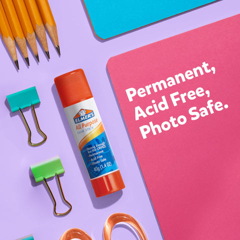Glue stick with orange cap and All Purpose label next to pencils, paper clips, and paper, text: Permanent, Acid Free, Photo Safe.