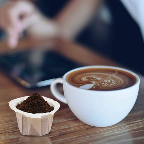 Disposable Coffee Filters 100 Count For Single Serve Brewers 1.0 And 2.0 White Paper next to cup of latte on table