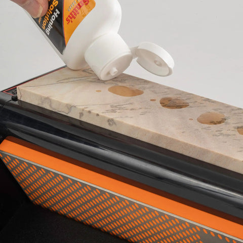Applying honing oil to Diamond Tri-Hone Bench Stone Set 8 Inch with Coarse Fine and Natural Arkansas Stones for knife sharpening.