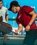 A player using an Elongated Pickleball Paddle With Toray T700 Carbon Fiber Face And Hyper Spin Technology Power1 Core 16mm Polypropylene Honeycomb For Pro Level Spin Control And Power on a court.