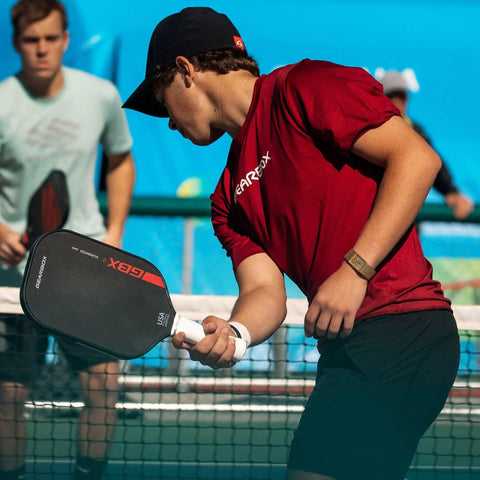 A player using an Elongated Pickleball Paddle With Toray T700 Carbon Fiber Face And Hyper Spin Technology Power1 Core 16mm Polypropylene Honeycomb For Pro Level Spin Control And Power on a court.