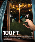 Person using remote for Outdoor Power Stake Timer With Six Grounded Outlets, Six Ft Extension Cord, 100 Ft Wireless Remote, Dusk To Dawn Photocell, Weatherproof Yard And Garden Lights, Easy No Fuss Remote Control, UL Listed, visible in a garden setting with string lights.