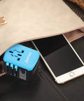 Universal USB Travel Power Adapter with Quad USB Ports and Type C for Worldwide Charging placed near smartphone in purse
