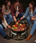 Group enjoying food around Smokeless Propane Fire Pit 53000 BTU Portable Outdoor Heater For Backyard Party Ready Patio Camping Beach Parties