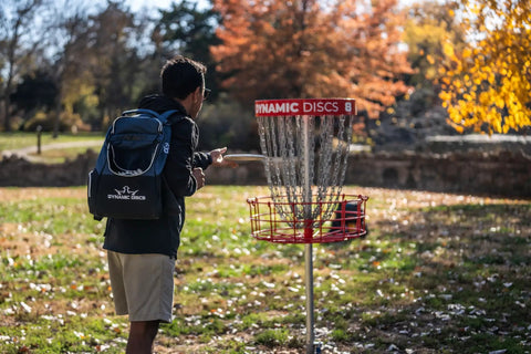 Man playing disc golf with Trooper Disc Golf Backpack Holds 18 Plus Discs, Lightweight Yet Tough Bag For Beginners, Black