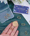 Eight Pieces Real 18K Gold Plated Brass Spring Gate Rings With Oval Clasps Carabiner Snap Hooks Keyring Buckles on table