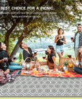 Group enjoying a picnic on a 9x18 Reversible Outdoor Camping Rug Weatherproof Patio Mat For RV Beach Backyard Deck And Picnic Two Gray And White Patterns Flip For A Fresh Look In An Instant, surrounded by trees.