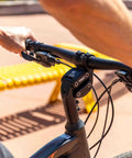Cyclist using Suspension Stem For Bicycle Handlebar With Adjustable Shock Absorption to reduce fatigue on a sunny day.