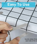 Hands using Heavy Duty Stainless Steel Tablecloth Clips 16 Pack For Outdoor Tables Stay Put No Slip Metal Picnic Table Clips on grid cloth