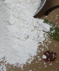 Close-up of Gypsum Powder For Clay Soil Solution Grade Calcium Sulfate Soil Amendment For Lawn And Garden Improving Drainage And Aeration, 97 Percent Purity, pH Neutral, Made In USA, Two Pounds, with a penny for scale.