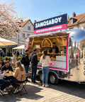 Commercial Grade 13 Foot Stainless Steel Food Trailer With Slick Mirror Polish serving food to customers at a busy outdoor location.
