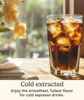 A glass of iced cold-extracted espresso on a wooden table with flowers in the background, highlighting a refreshing espresso drink.