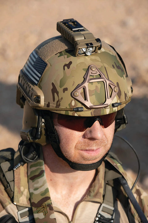 Sidewinder 55 Lumen LED Military Flashlight on helmet MOLLE mount in use outdoors, featuring 185 degree tilt and weather resistance